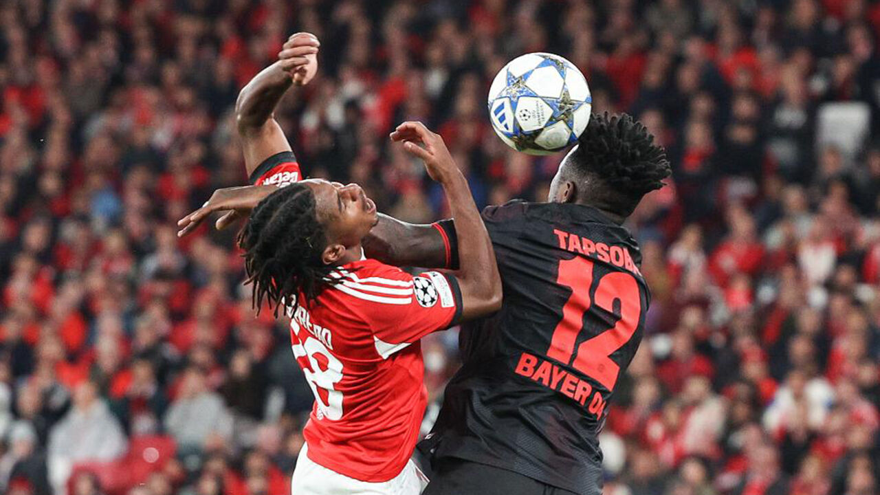 Jogadores do Benfica e Bayer Leverkusen disputam a bola durante um jogo