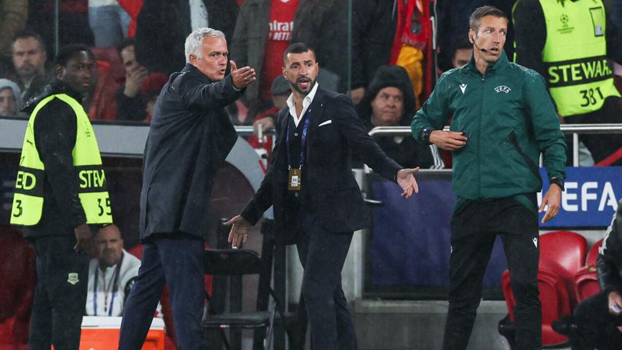 Mourinho gesticula no banco, com elementos da equipa técnica e segurança próximos