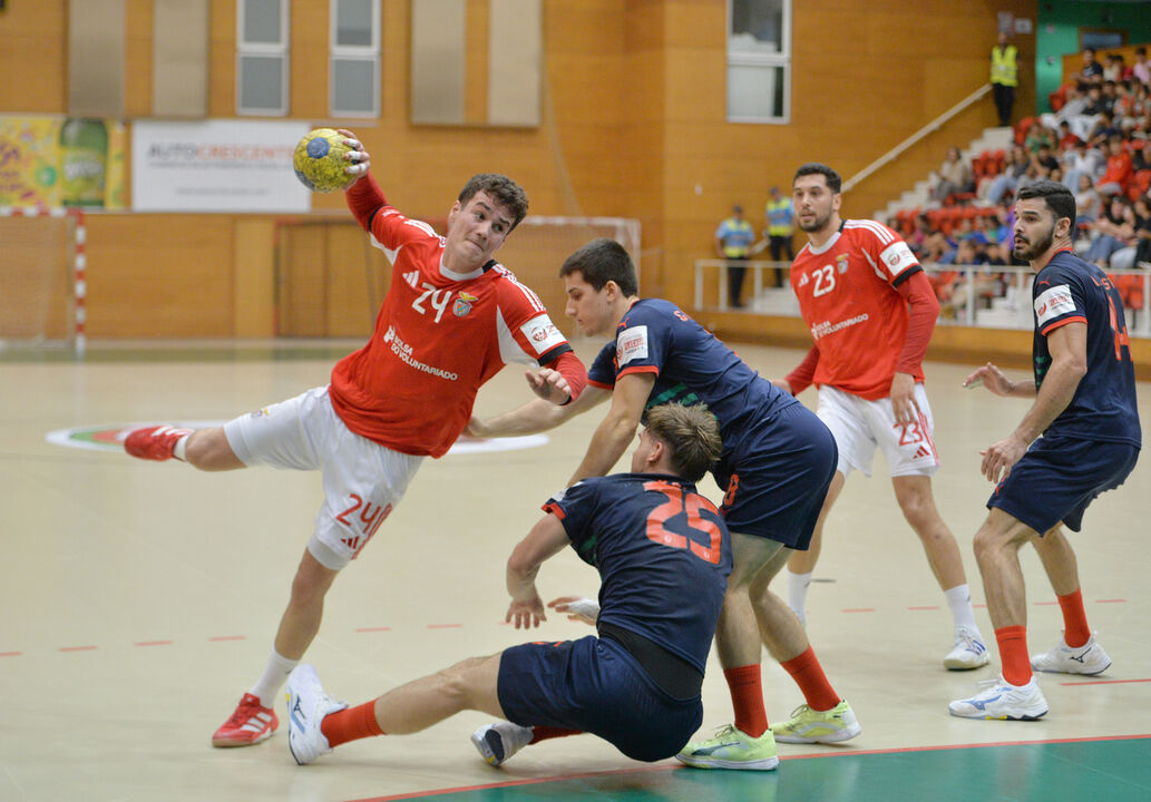 Jogo de andebol com atletas em disputa pela posse de bola