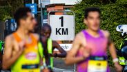 Atletas correm na marca de 1 km durante uma maratona