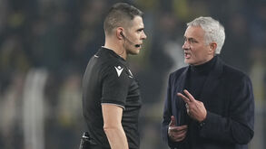 José Mourinho conversa com o árbitro Simone Sozza durante o Fenerbahçe-Lyon, na Liga Europa