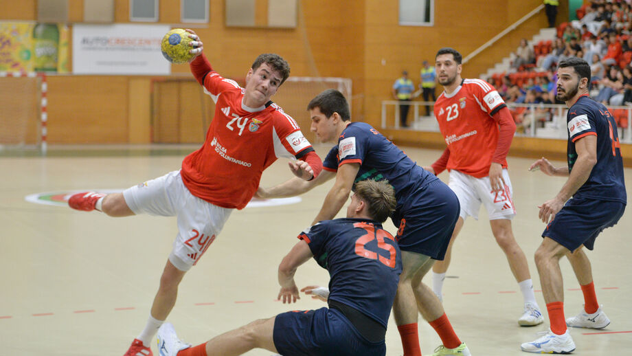 Jogo de andebol com atletas em disputa pela posse de bola