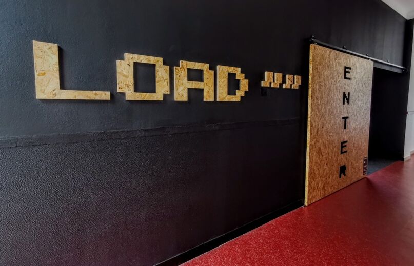 Decoração com palavras 'Load', 'Enter' e elementos que remetem para o universo dos jogos