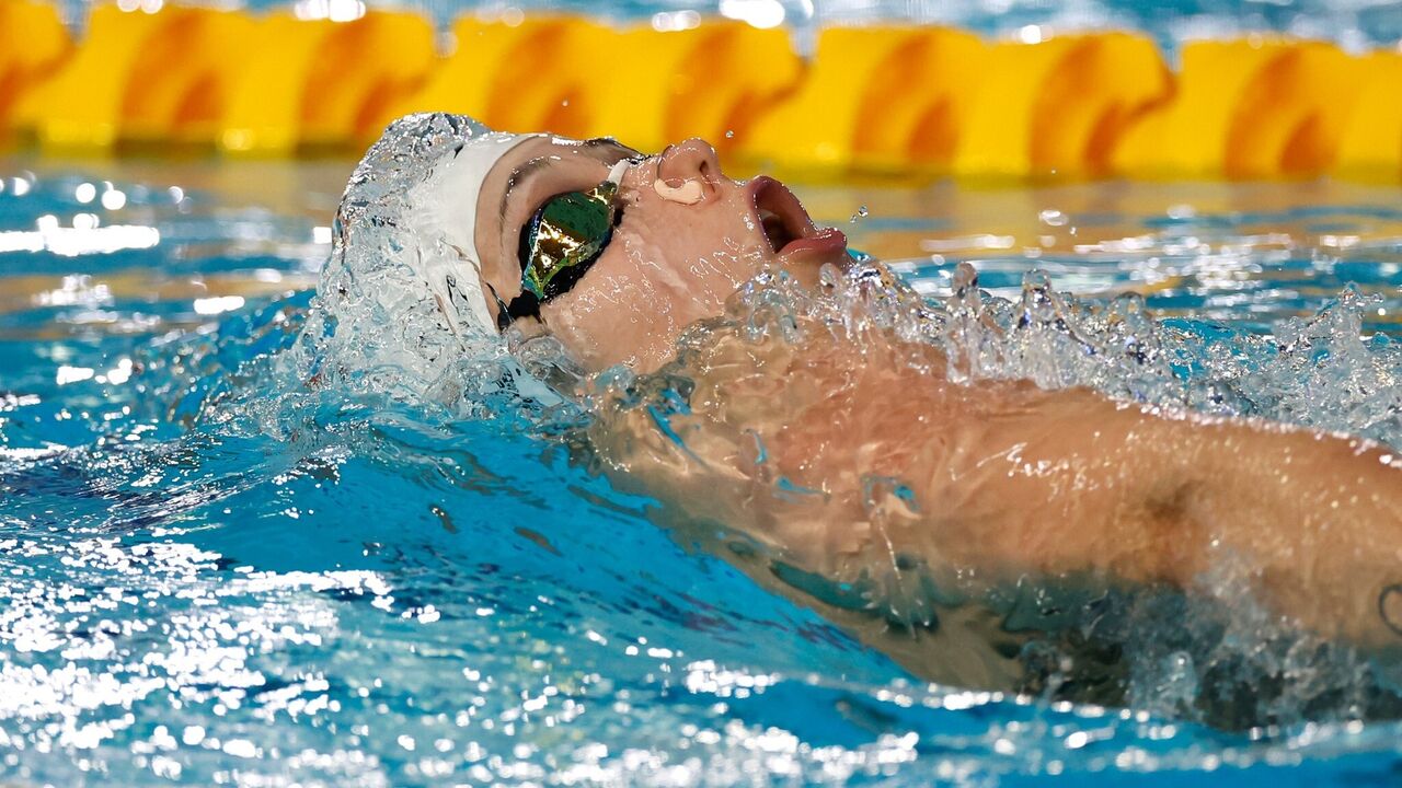 Nadadora compete em piscina com óculos de proteção e touca