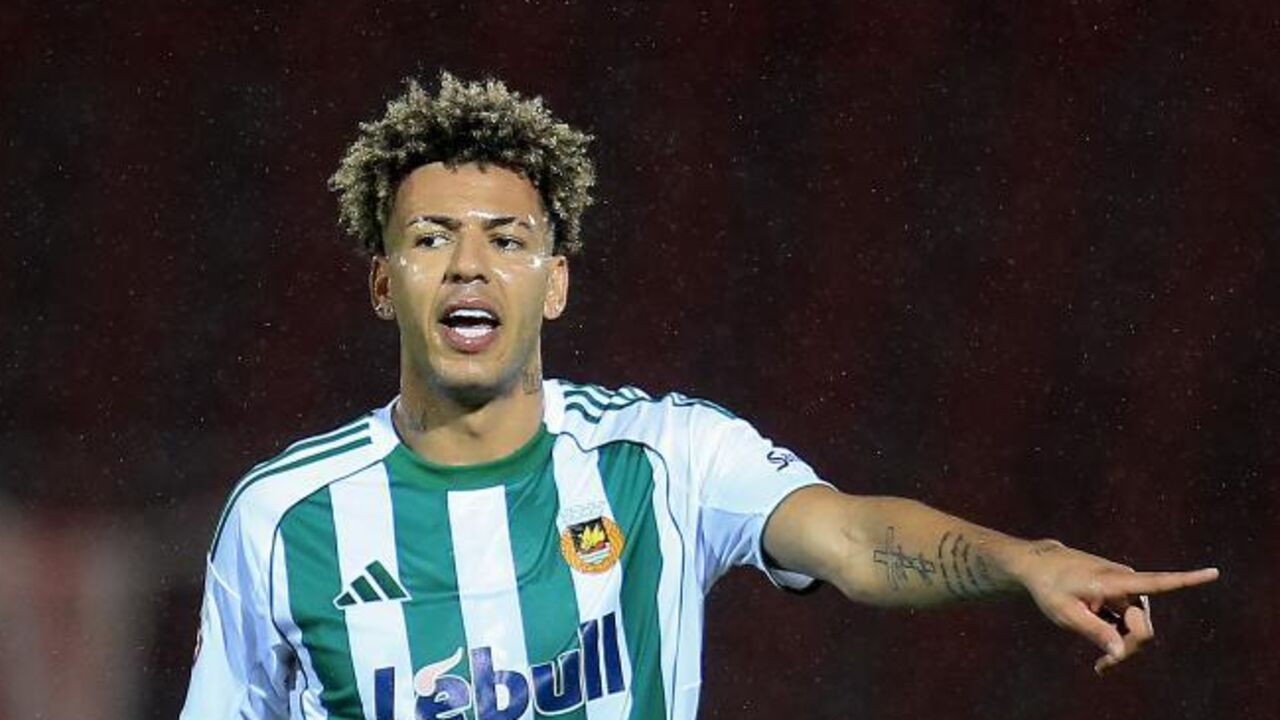 Jogador de futebol com a camisola do Lebull aponta para algo