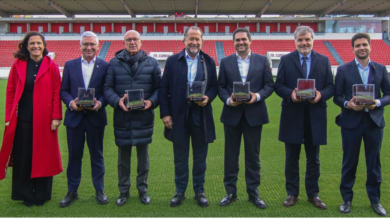 Grupo de pessoas posa com relva do Estádio Municipal de Braga