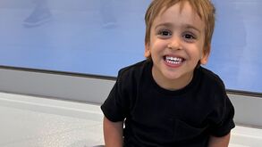 Dinis sorri enquanto assiste a um jogo de futsal, com apoio da Associação Salvador.
