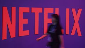 Logótipo da Netflix com pessoa desfocada em frente