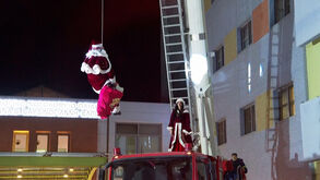 Bombeiros gregos fazem rapel em fachada de hospital para entregar prendas a crianças doentes