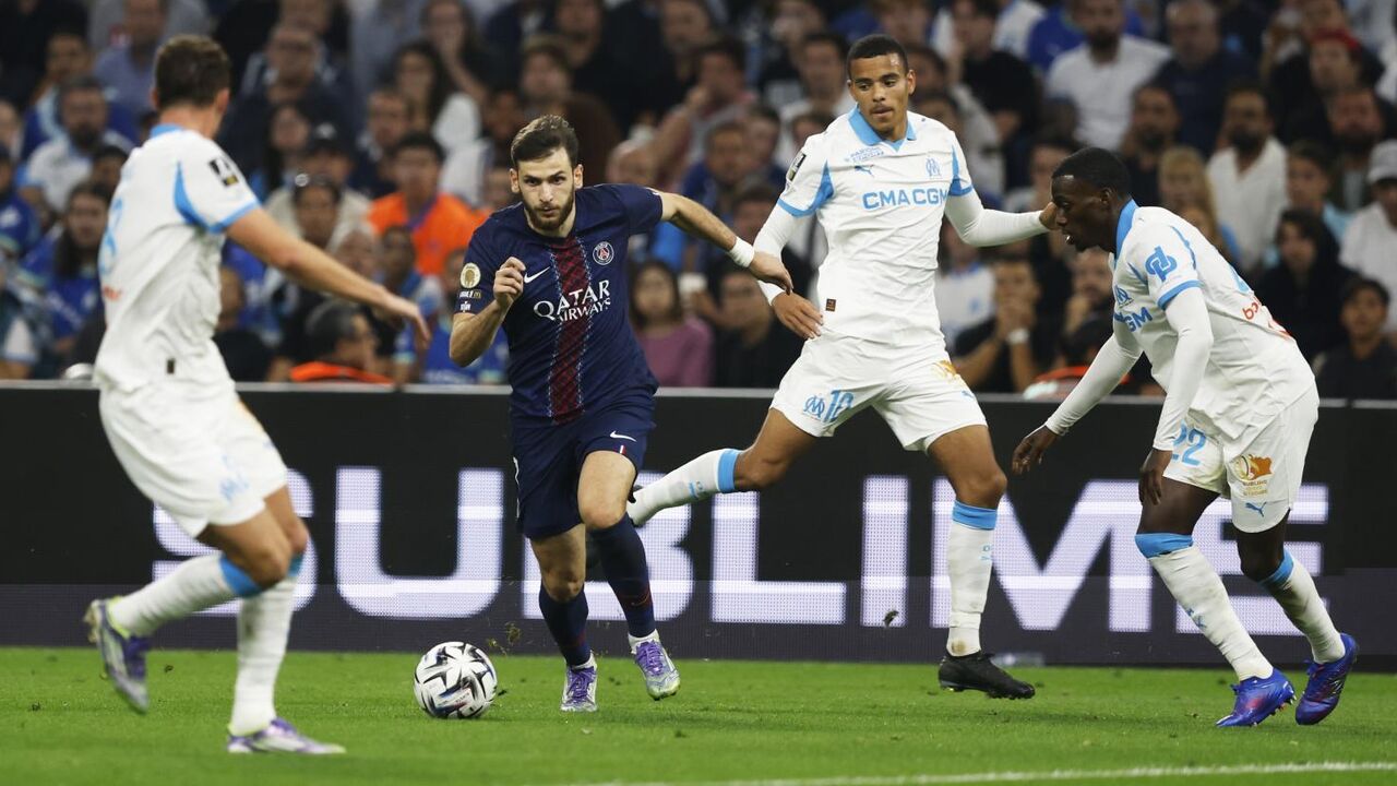 Jogo de futebol entre PSG e Marselha, com disputa da bola em campo