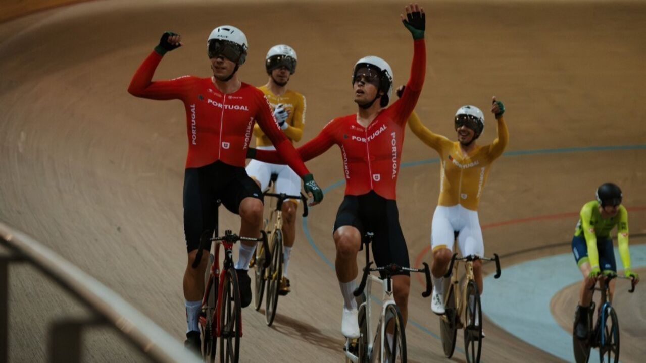 Ciclistas portugueses festejam numa pista, com equipamentos nas cores da bandeira