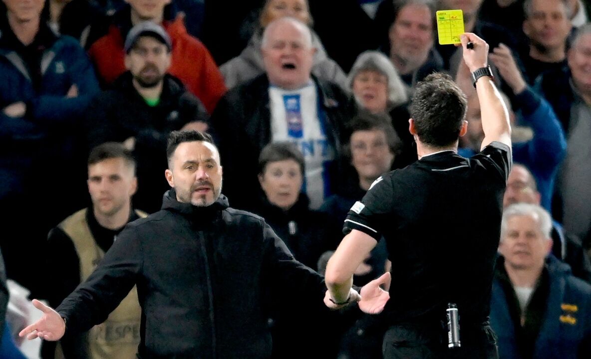 Árbitro mostra cartão amarelo durante jogo de futebol