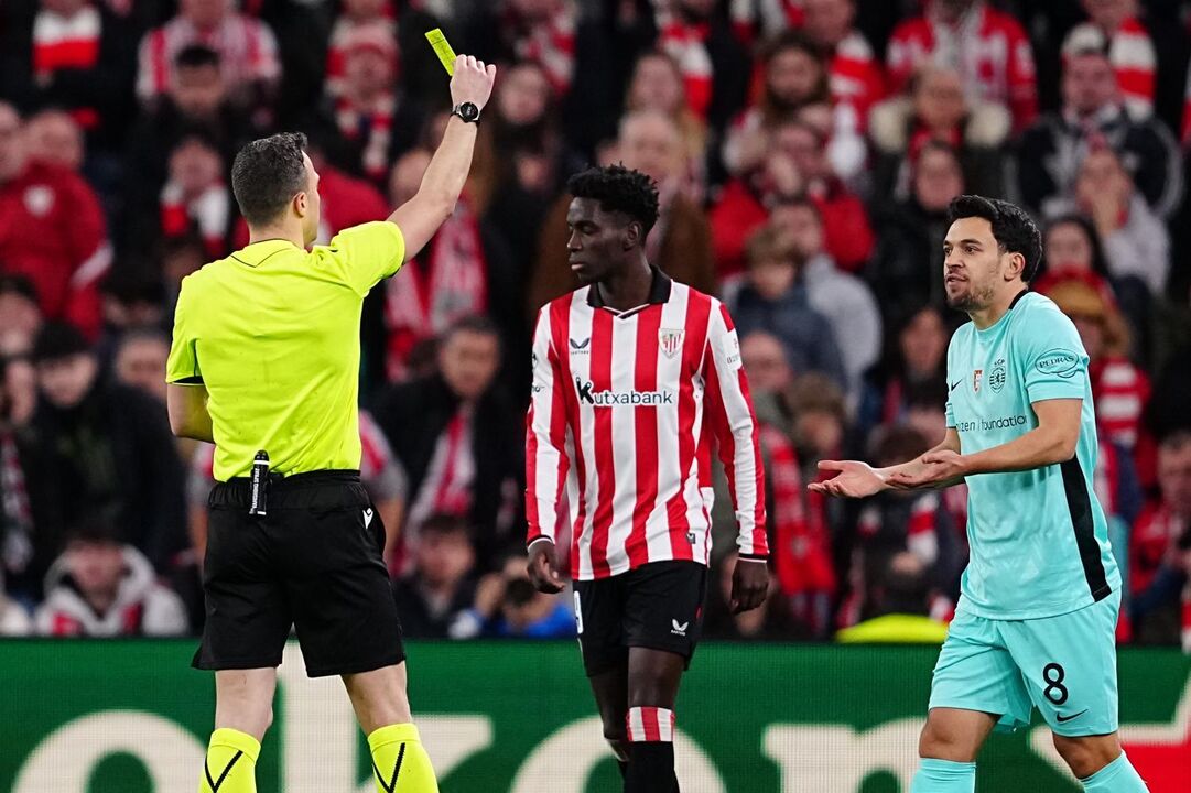 Árbitro mostra cartão amarelo durante jogo