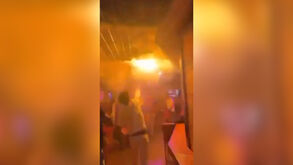 Novas imagens mostram jovem a tentar apagar incêndio em bar na Suíça   