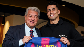 João Cancelo ao lado de Joan Laporta com a camisola do Barcelona