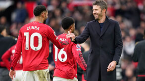 Michael Carrick sorridente a cumprimentar os jogadores após vitória no dérbi de Manchester