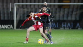 Jogadores de AVS SAD e Casa Pia lutam pela posse de bola num relvado encharcado