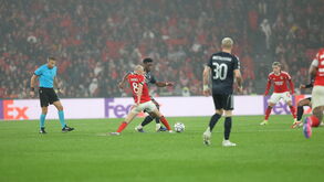 Jogo de futebol entre Benfica e Real Madrid com árbitro em campo