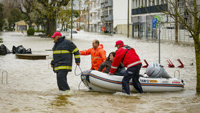 Bombeiros ajudam mulher após os efeitos da passagem da depressão Kristin