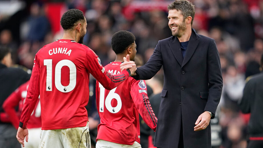 Michael Carrick sorridente a cumprimentar os jogadores após vitória no dérbi de Manchester