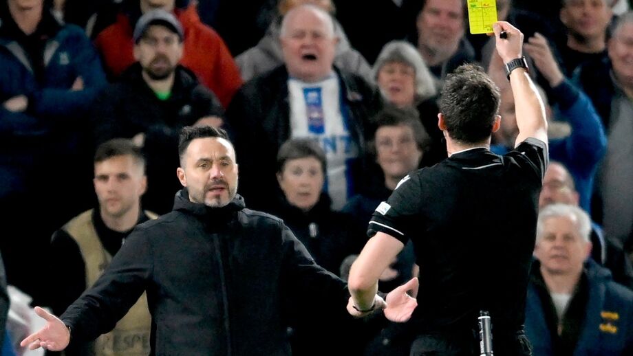 Árbitro mostra cartão amarelo durante jogo de futebol