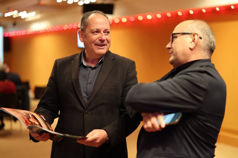 Dois homens de fato conversam num evento