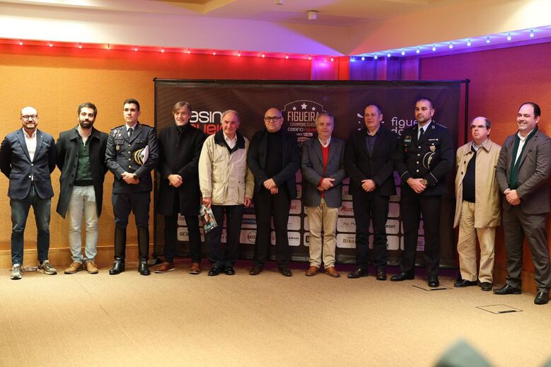 Grupo de pessoas posa em frente ao banner Figueira Champions Class