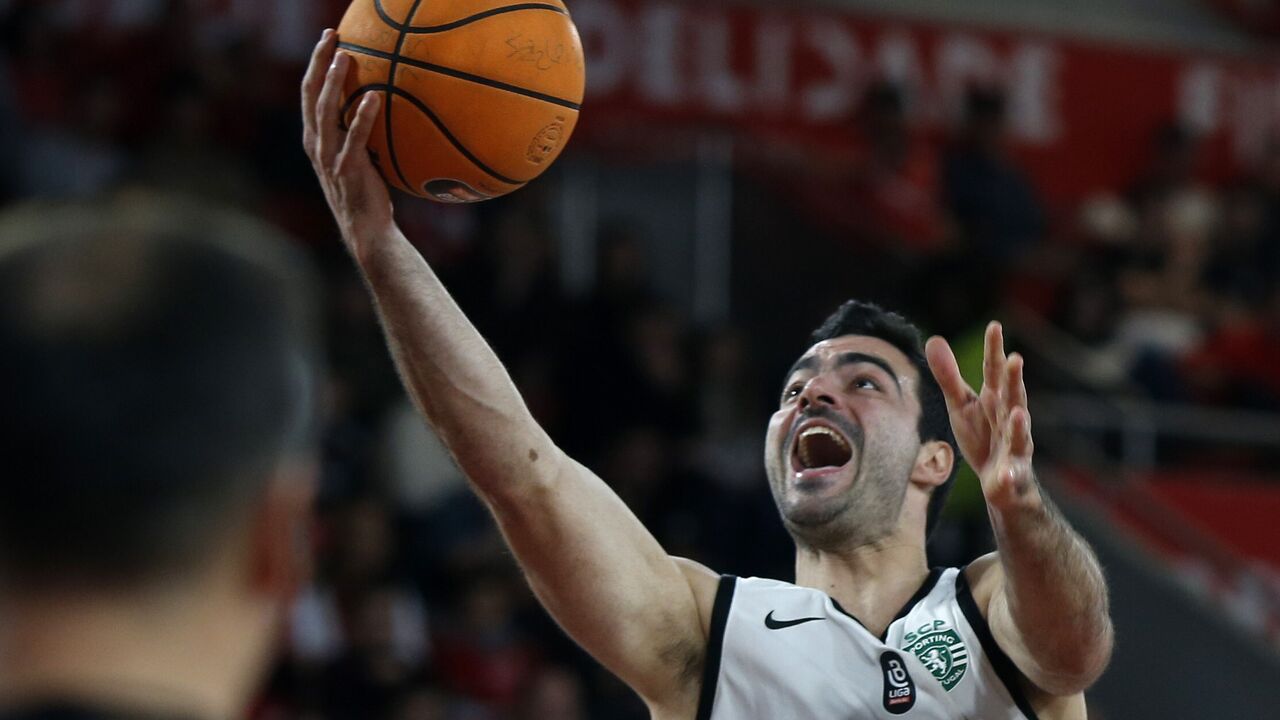 Basquetebolista em jogo pelo Sporting CP com bola na mão