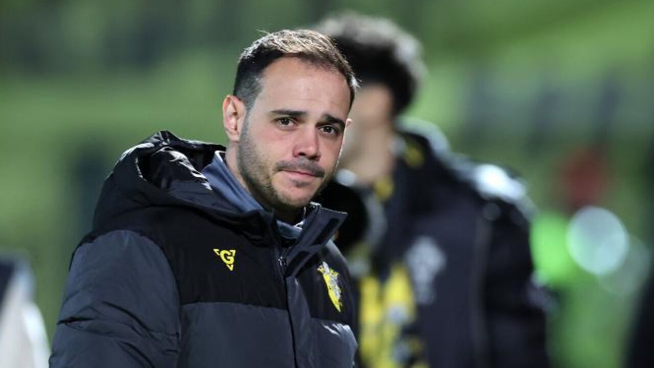 Treinador de futebol com casaco do clube