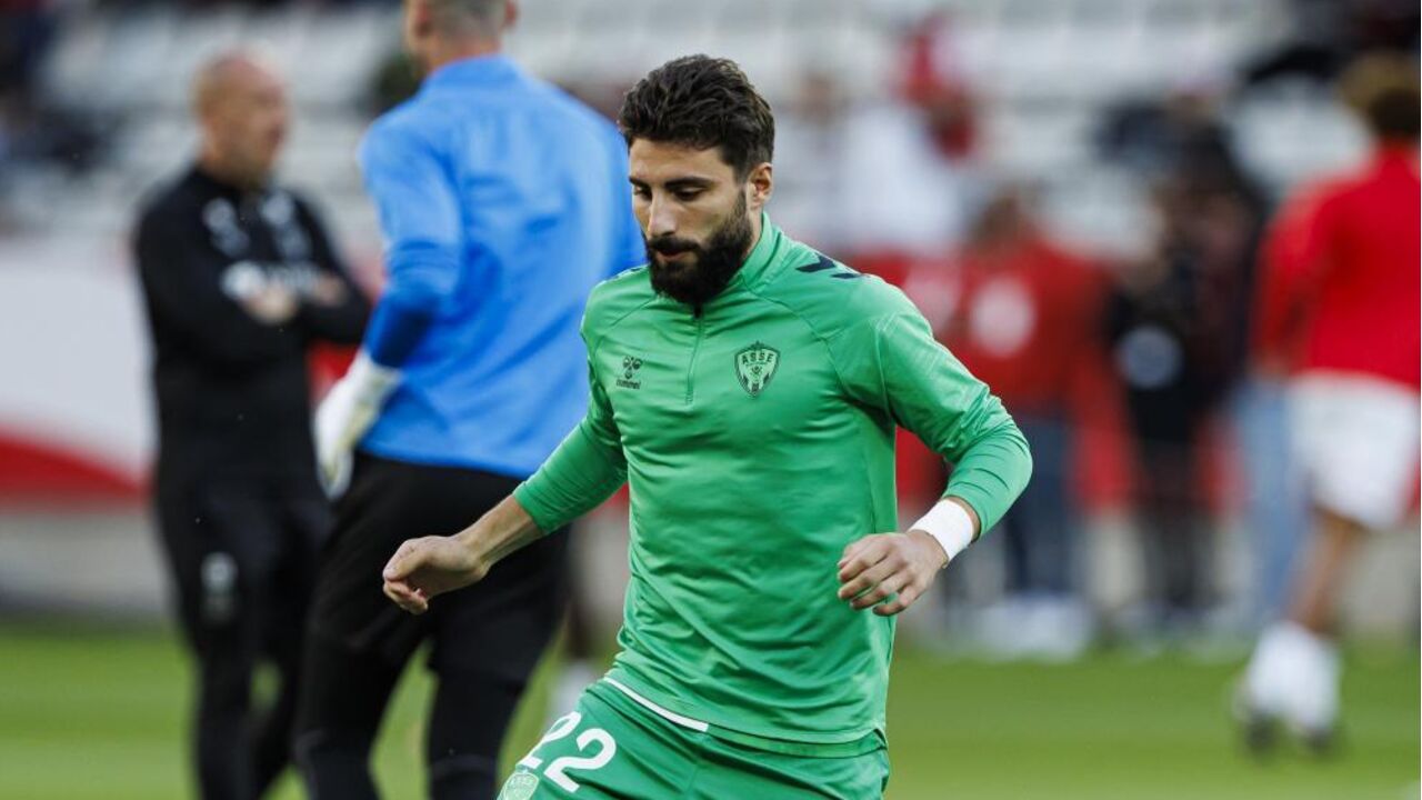 Jogador de futebol com a camisola verde número 22 em campo