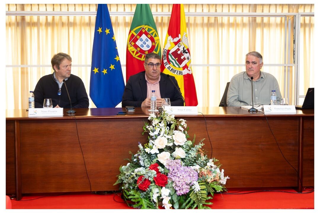 Jorge Carmo, Nuno Pissarra e Francisco Paula numa mesa com as bandeiras de Portugal, Europa e Albufeira