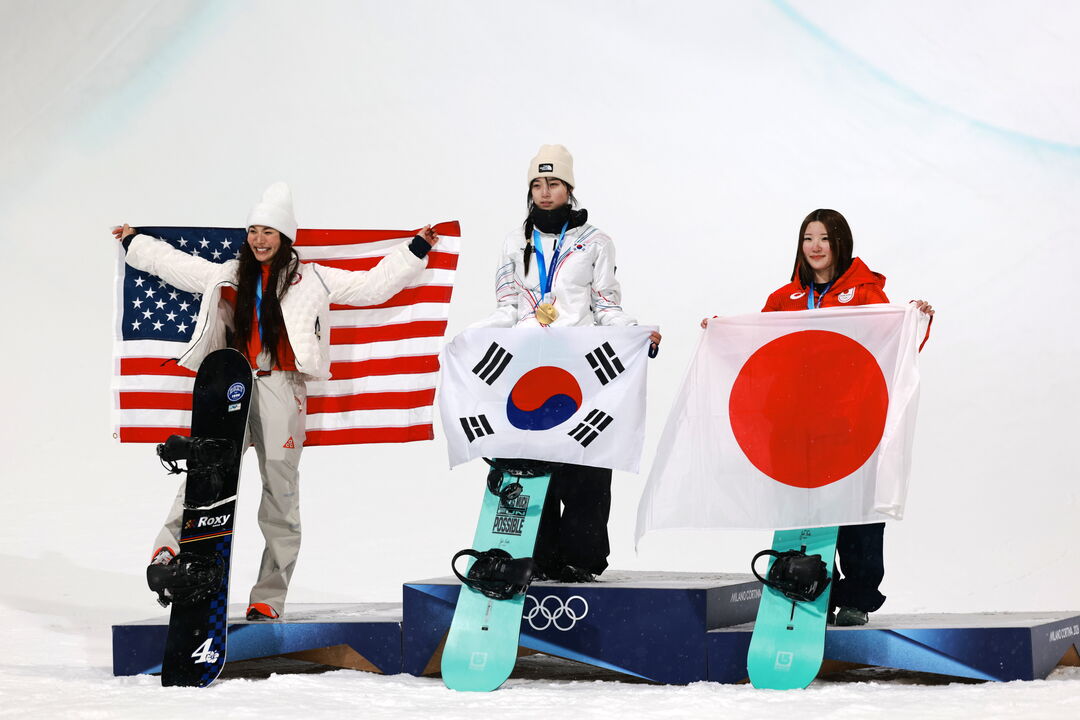 Atletas com bandeiras dos EUA, Coreia do Sul e Japão no pódio