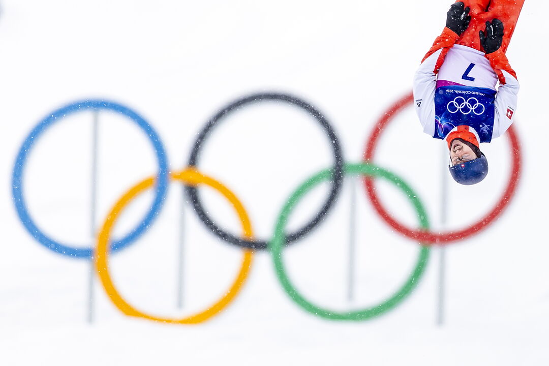 Atleta nos Jogos Olímpicos de Inverno, com os anéis olímpicos ao fundo