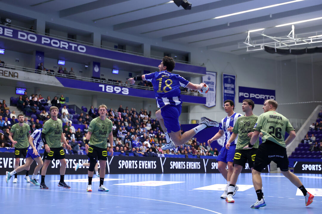 Jogo de andebol com atleta do FC Porto no ar a lançar a bola