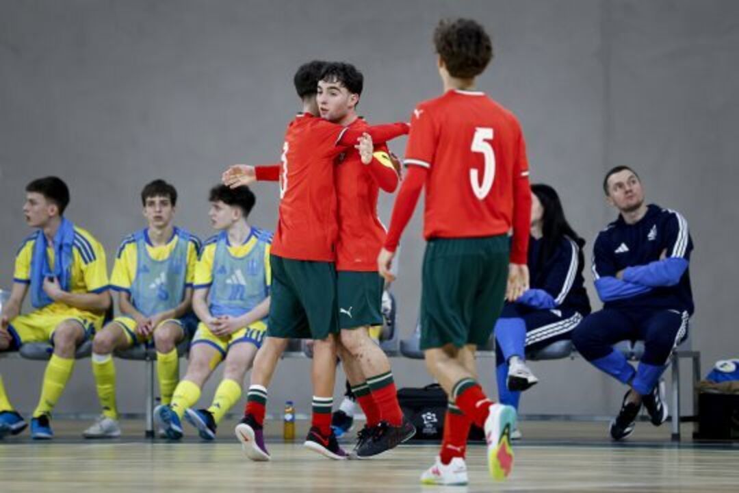 Jogadores de futsal celebram em campo com equipas adversárias nos bancos