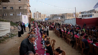 Centenas de pessoas reúnem-se entre escombros na Faixa de Gaza para a primeira refeição do Ramadão  