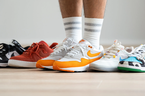 Variedade de ténis Nike e meias brancas com riscas