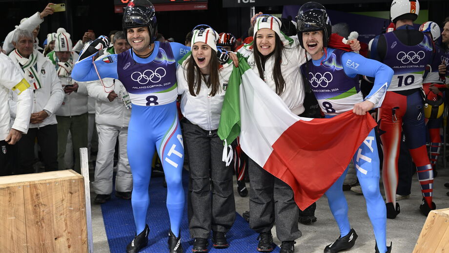 Atletas italianos celebram com a bandeira de Itália