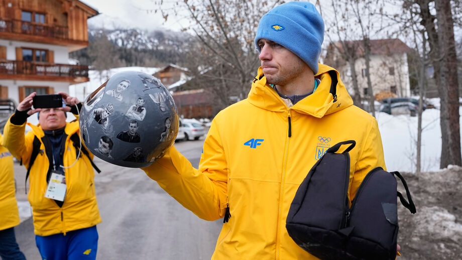 Atleta ucraniano com capacete de homenagem, após exclusão em Cortina d'Ampezzo