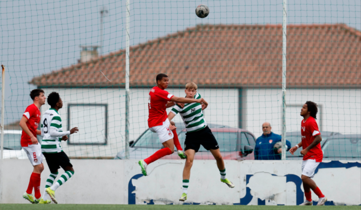 Jogadores disputam bola em partida de futebol
