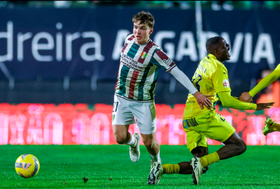 Jogador disputa a bola durante um jogo de futebol