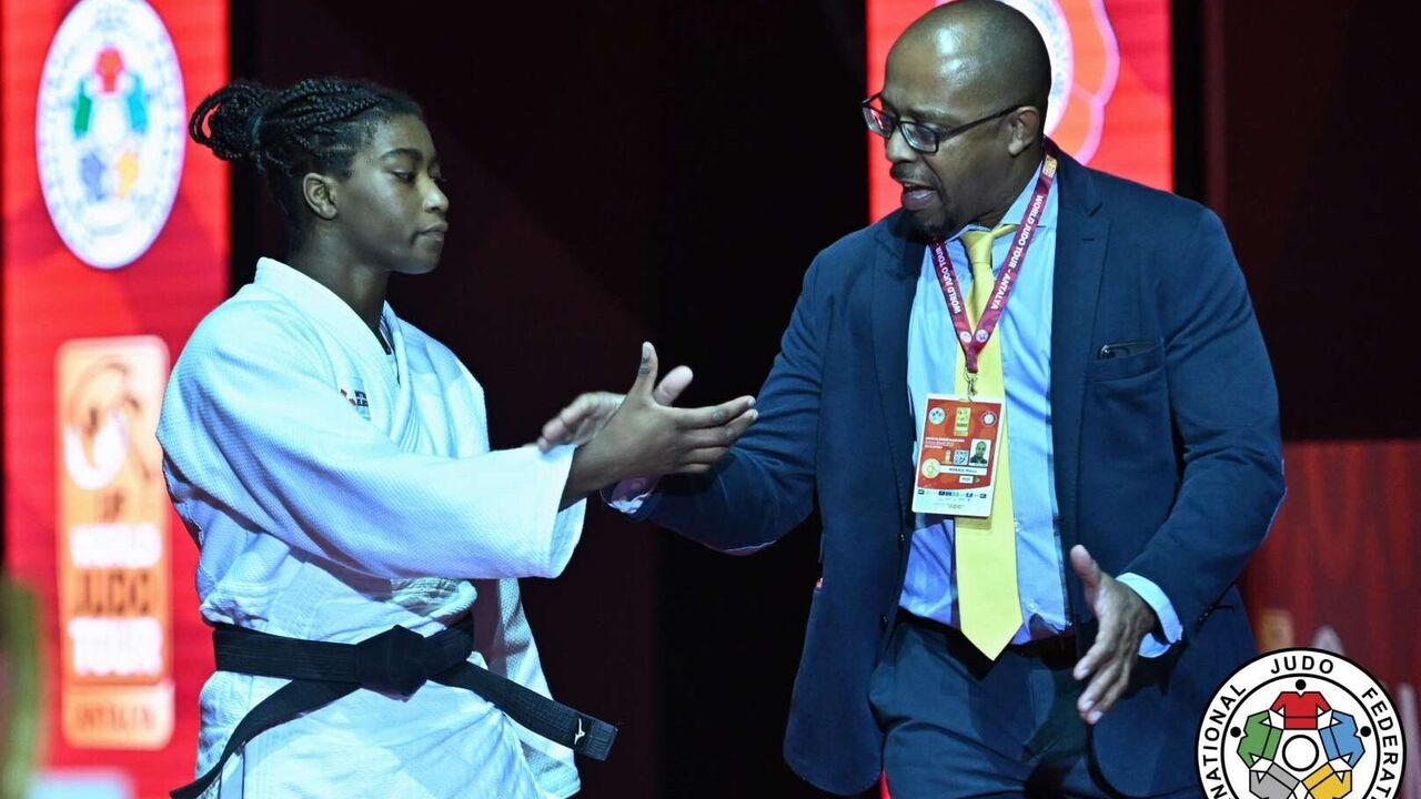 Judoca e treinador cumprimentam-se no Campeonato do Mundo de Judo