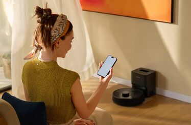 Mulher usa smartphone para controlar Roborock Q7TF Plus