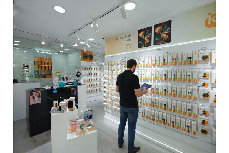 Homem consulta tablet em loja de reparação de tablets