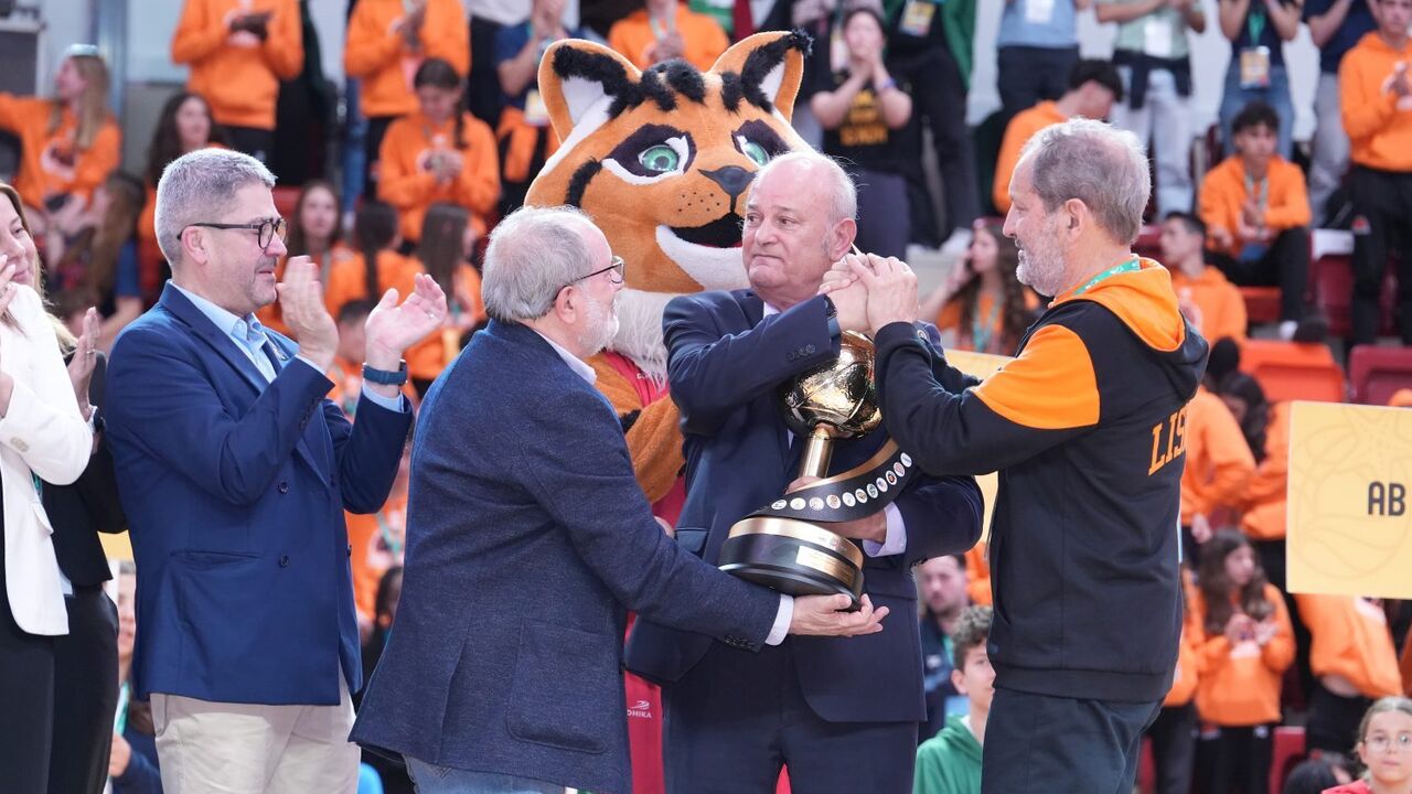 Cerimónia de entrega de troféu com pessoas, uma mascote e público