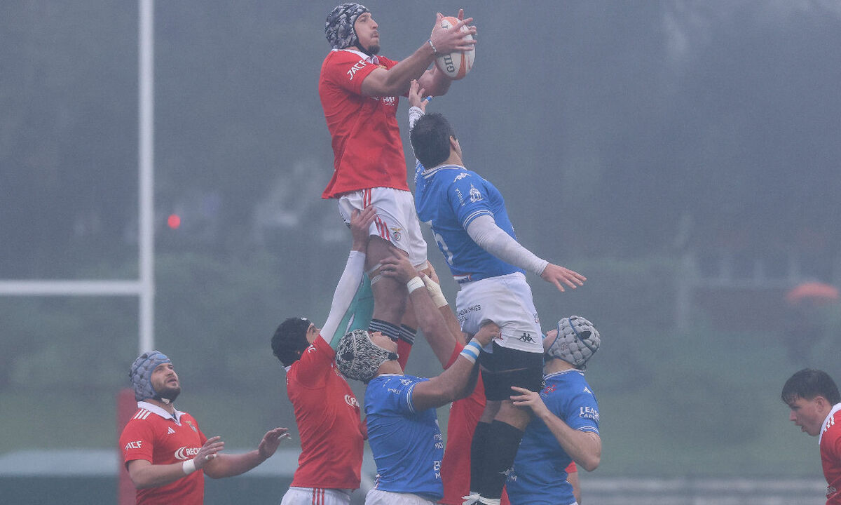 Jogo de râguebi com atletas a disputar a posse da bola