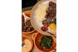 Prato de feijoada com arroz, laranja, couve e farofa