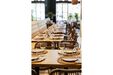 Restaurante com mesas postas e cadeiras de vime