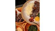 Prato de feijoada com arroz, laranja, couve e farofa