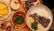 Prato de feijoada, arroz, couve, farofa, laranja e linguiça